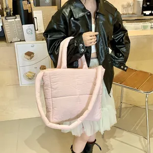 Dettaglio di una borsa trapuntata rosa grande con texture morbida e tracolla regolabile