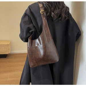 Close-up of vintage dark brown PU leather shoulder bag with gold hardware detail