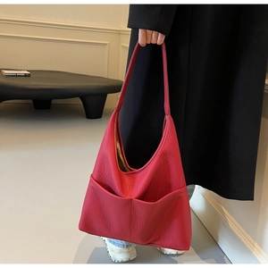 Detail of red PU leather tote bag with lychee texture and dual front pockets