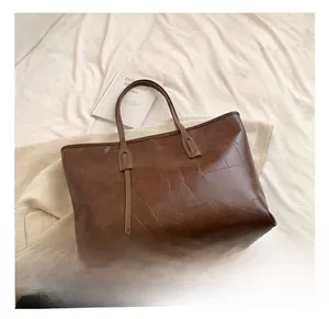 Close-up of deep brown PU leather tote bag with geometric embossed texture for women