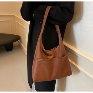 Detail of vintage brown pebbled leather shoulder bag with two large front pockets