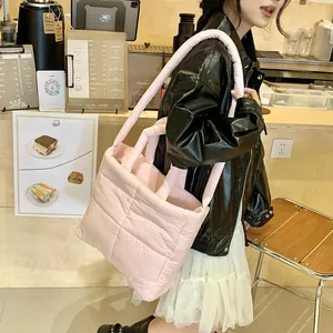 Dettaglio della borsa a tracolla in nylon trapuntato rosa con spallina imbottita su modella