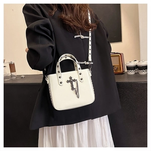 Detail of white PU crossbody bag with gothic metal cross, chain, and stud accents