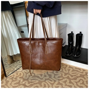 Close-up of dark brown tote bag featuring unique rectangular geometric patchwork and texture