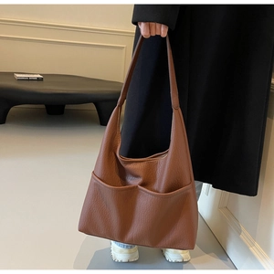 Detail view of caramel brown lychee leather Hobo bag with stylish front double pockets