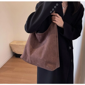 Brown suede tote bag shown on model with minimalist retro design for autumn wear