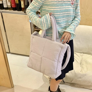 Vista dettagliata della borsa tote trapuntata in velluto a coste viola chiaro indossata