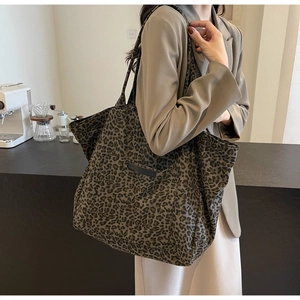Détail du sac cabas en toile à motif léopard avec un empiècement noir décoratif à l'avant