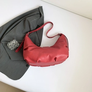 Sac hobo rouge en cuir PU avec détails plissés posé sur un costume gris élégant