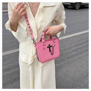 Detail of pink PU leather crossbody bag with gothic black cross and silver rivets