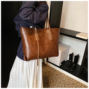 Detailed view of brown PU leather tote bag with unique geometric patchwork texture design