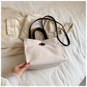 Chic cream fleece tote bag with brown leather handles and a long shoulder strap