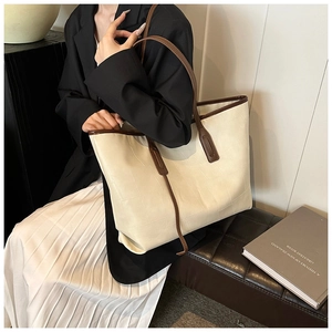 Detail of minimalist tote bag with checkered embossing and contrast brown handles