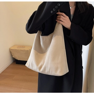 Detailed view of the soft beige suede tote bag texture and spacious shoulder strap design