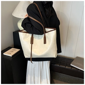 Lifestyle view of a large cream PU leather tote bag with geometric embossed texture