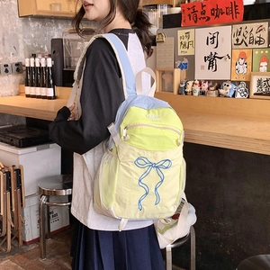Detailansicht eines bunten Rucksacks mit Schleifenstickerei und seitlicher Netztasche