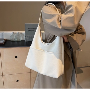 Detailed macro view of white pebble leather tote bag with functional front pockets