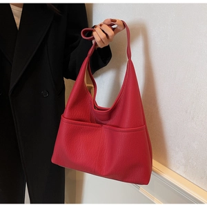 Detail of red Hobo shoulder bag showing premium pebble grain PU texture and front arc pockets