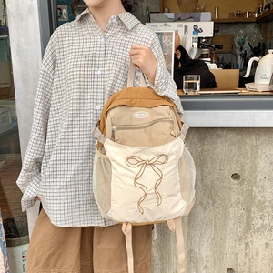 Detail eines modischen Color-Block Rucksacks mit großer Schleifenstickerei und Netzfach