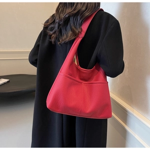 Detail of red litchi texture PU leather tote bag with functional exterior pockets