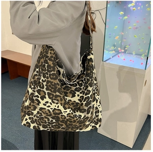 Détail d'un grand sac cabas à imprimé léopard avec bandoulière large porté par un modèle