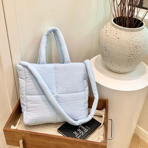 Elegante borsa tote in tessuto trapuntato azzurro con tracolla e cuciture a onde