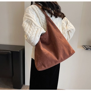 Detail of a brown suede tote bag with a slouchy design showing premium fabric texture