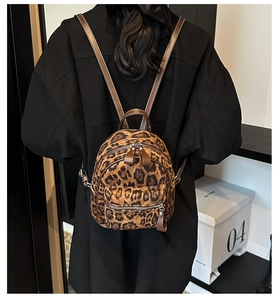 Detalle de mini mochila con estampado de leopardo con correas de cuero marrón y textura