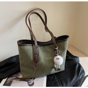 Green velvet tote bag with diamond quilted stitching and brown leather shoulder straps