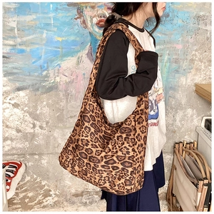 Detailed side view of large leopard print canvas tote bag on model for casual wear