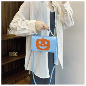 Detail of light blue PU handbag featuring a creative orange pumpkin face design for Halloween