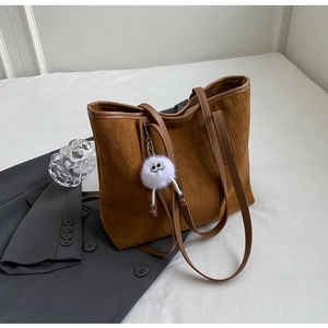Caramel velvet tote bag with vertical stitching and white plush doll pendant decoration