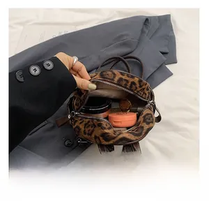 Capacidad interna de mochila de leopardo con cosméticos como lápiz labial y polvos faciales