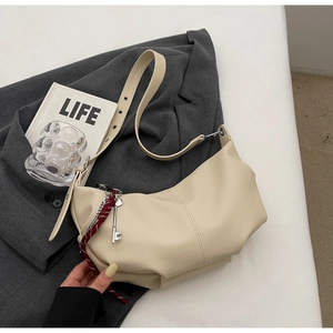 Chic cream PU leather half-moon crossbody bag with silver charm and woven rope detail