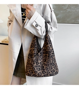 Détail d'un sac porté épaule tendance imprimé léopard porté avec un trench-coat d'automne
