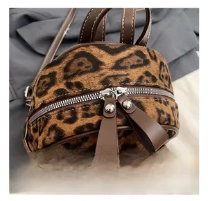 Detalle de mochila de leopardo en piel sintética con cremallera de metal y tirador largo