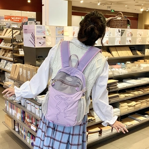 Detailansicht lila Nylon-Rucksack mit Schleifenstickerei und grauem Reißverschluss