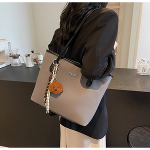 Chic grey canvas tote bag with black leather trim and cute brown puppy plush keychain