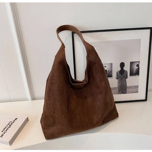 Detailed close-up of dark brown suede tote bag with smooth leather strap for work