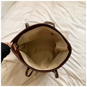 Detailed interior of the brown PU leather shoulder bag showing spacious pockets and lining
