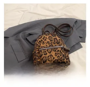 Detalle de mochila con estampado de leopardo mostrando correas de cuero y costuras