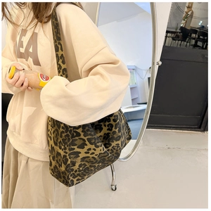 Détail montrant le grand sac cabas à imprimé léopard porté à l'épaule pour femme