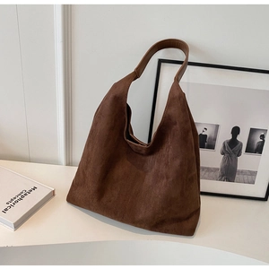 Detail of retro large capacity tote bag in dark coffee suede with textured finish