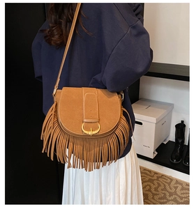 Close-up of bohemian dark camel suede crossbody bag with dense fringe details