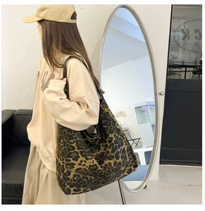 Vue détaillée d'un grand sac cabas en toile à imprimé léopard porté par un mannequin