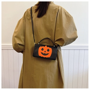 Chic black PU shoulder bag featuring an orange Halloween pumpkin Jack-o'-lantern patch design
