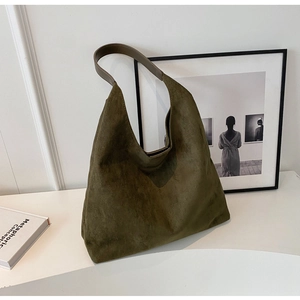 Detailed view of the dark green suede tote bag with brown leather shoulder straps