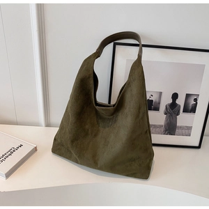 Detail of vintage olive green suede hobo bag with deep brown leather handle and texture