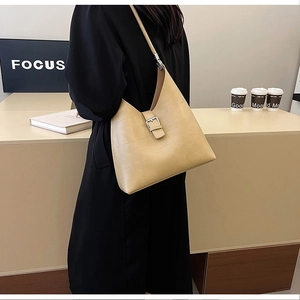 Détail de la texture géométrique gaufrée et de la boucle en métal argenté sur le sac beige