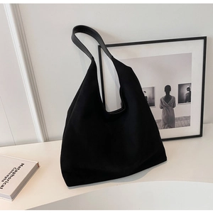 Close-up of black suede tote bag texture with minimalist interior decor for daily commute
